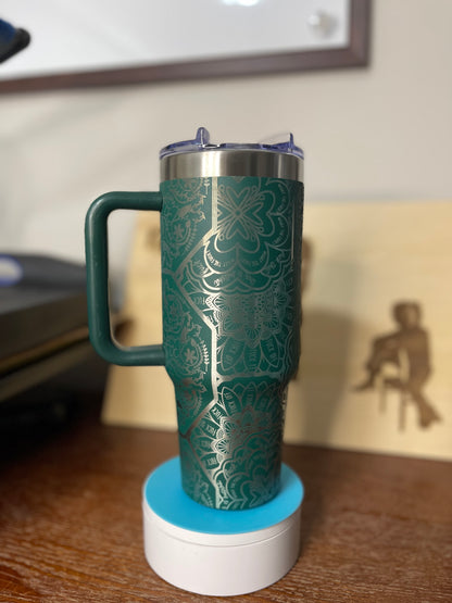 Green thermos with handle on a white base against a blurred background
